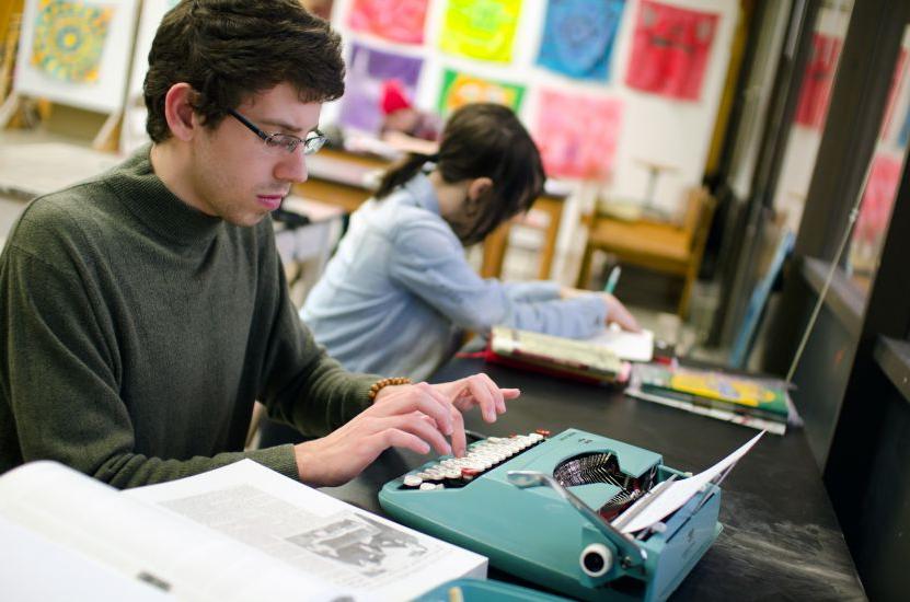A student uses a typewriter during an on-campus J-Term course. 
